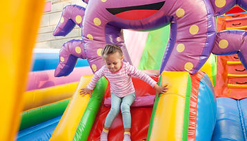 Chica jugando en el castillo hinchable