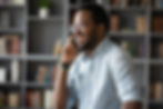 African American business owner speaking to a contractor on the phone.
