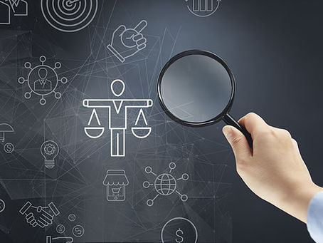 Man's hand with magnifying glass looking at objects on a black board