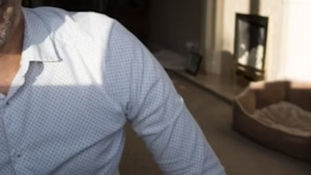 Man in overhemd, met kamer op achtergrond