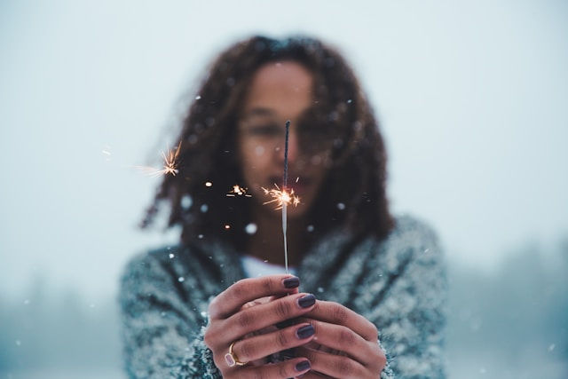 Vrouw in de sneeuw met een lichtje in haar handen
