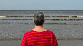 Vrouw die uitkijkt op zee