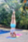 Elfi Scheffers staat in de yoga hoofdstand naast een zwembad in Costa Rica