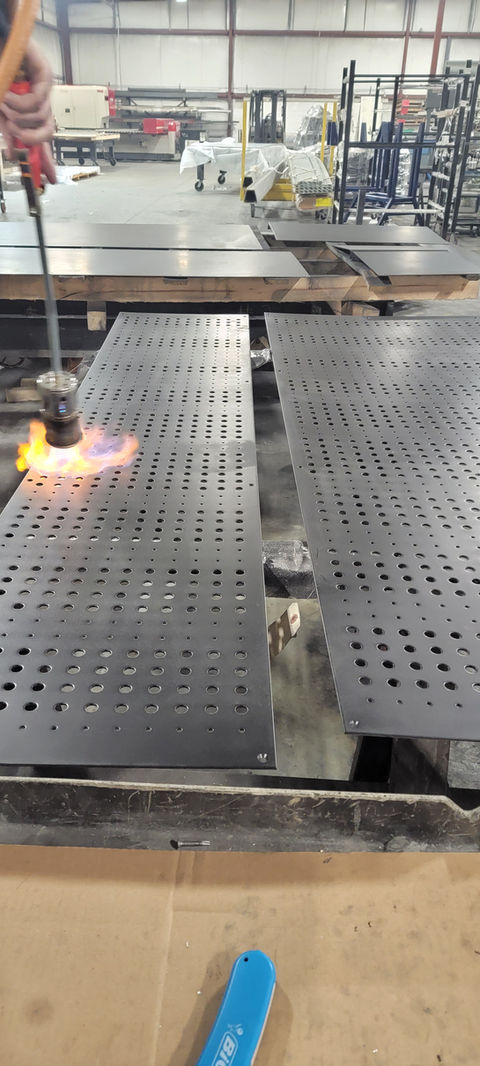 Steel panels, perforated metal panels, 11 GA steel panel assemblies, custom hand applied finish, blackened patina finish, patina finish, patina finish on steel, custom assembled metal panel system.