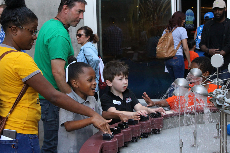 1st grader and her mom play in the water exhibit