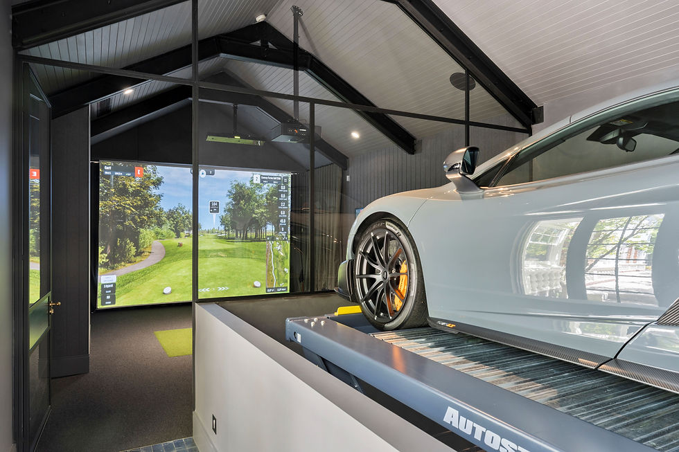Luxury home golf simulator installed by Golfsim viewed through glass partition with sports car in adjacent garage