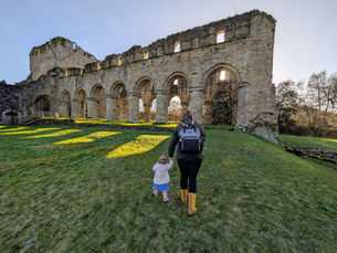 A mum and toddler exploring the grounds of Buildwas Abbey near Telford