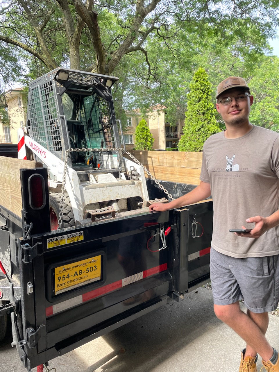 Worker with skid steer for efficient junk removal