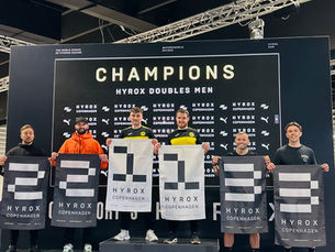 6 men stood on a podium holding flags