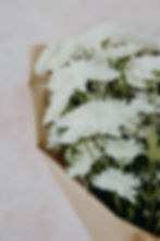 זר פרחים לבנים עטוף בנייר