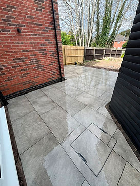 natural-stone-patio-garden-fencing-grey-tiles-drain-cover.jpeg