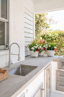 Custom outdoor kitchen with built-in sink, countertop workspace, and decorative finishes designed for outdoor entertaining.