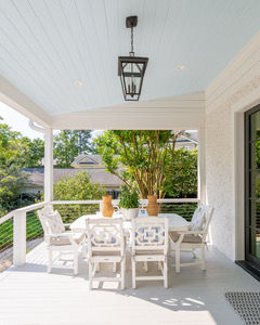 Outdoor dining space featuring a covered patio, architectural lighting, and seating designed for family gatherings and entertaining.