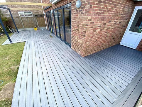 large grey composite decking area surrounding the house with a custom made timber pergola in chislehurst, kent