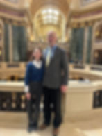Two people stand together inside the WI state Capitol building.