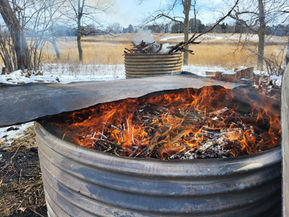 A fire burns in a biochar kiln.