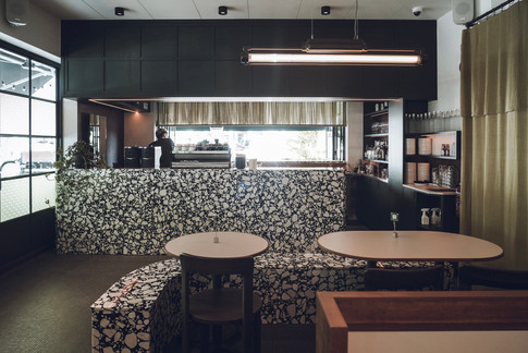 Contemporary cafe environment shaped through natural light and greenery