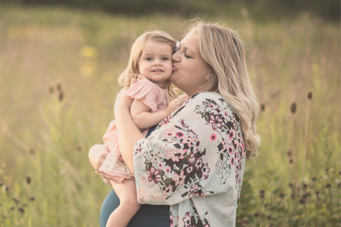 Pregnant woman outdoors kissing child baby and representing connection