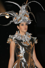 Mannequin portant une création de Richard Robinson Maître Couturier avec coiffe extravagante.