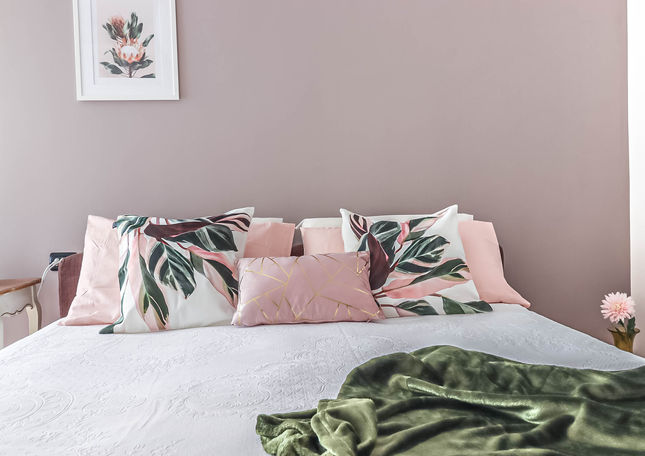 La camera da letto trasmette un'atmosfera romantica, con un angolo lettura affacciato sul terrazzino e un letto spazioso ornato da cuscini accoglienti.