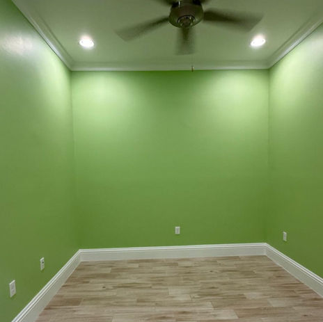 Freshly painted green room with clean white crown molding and recessed ceiling lights