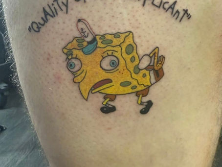 Close-up of a SpongeBob meme tattoo on a person’s thigh with the caption ‘Quality of the Applicant,’ symbolizing humor, individuality, and resilience in the author’s story.