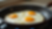 Close-up view of a skillet with perfectly cooked sunny-side-up eggs
