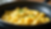 Eye-level view of a non-stick pan with softly scrambled eggs