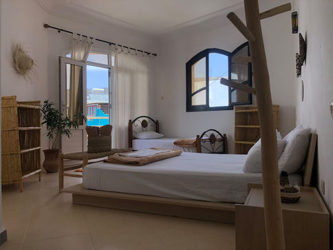 Habitación triple con cama grande, otra pequeña y baño en suite en Arima Surf House