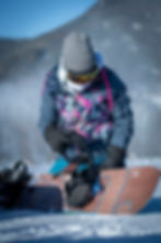 Snowboarder adjusting bindings and board equiped with ShredLORD