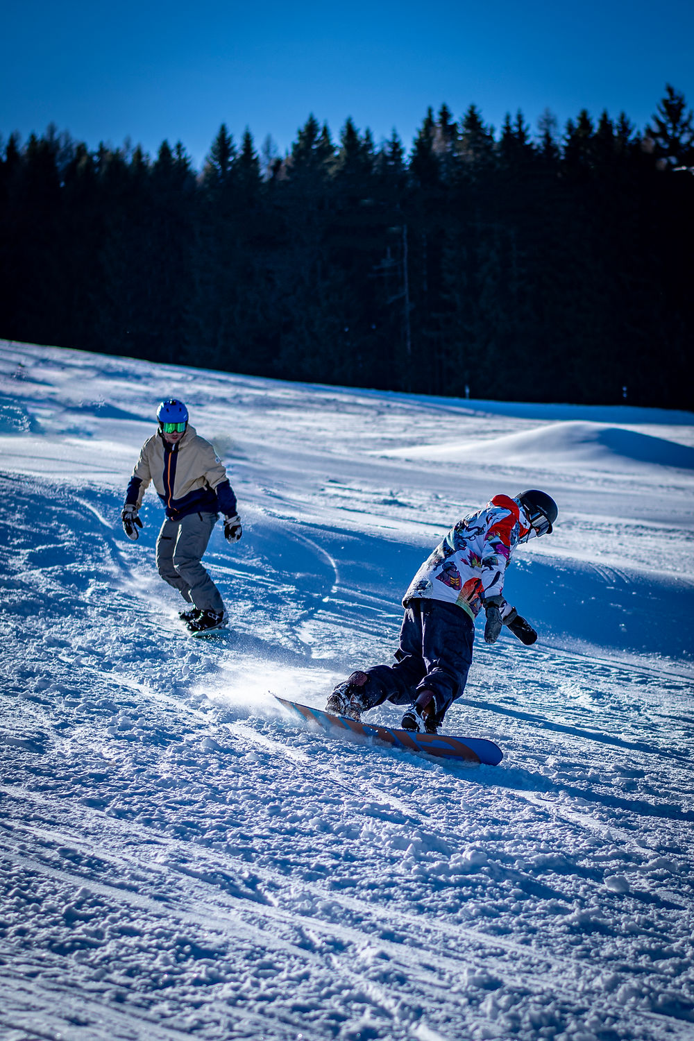 Two snowboarders on a snowy mountain slope