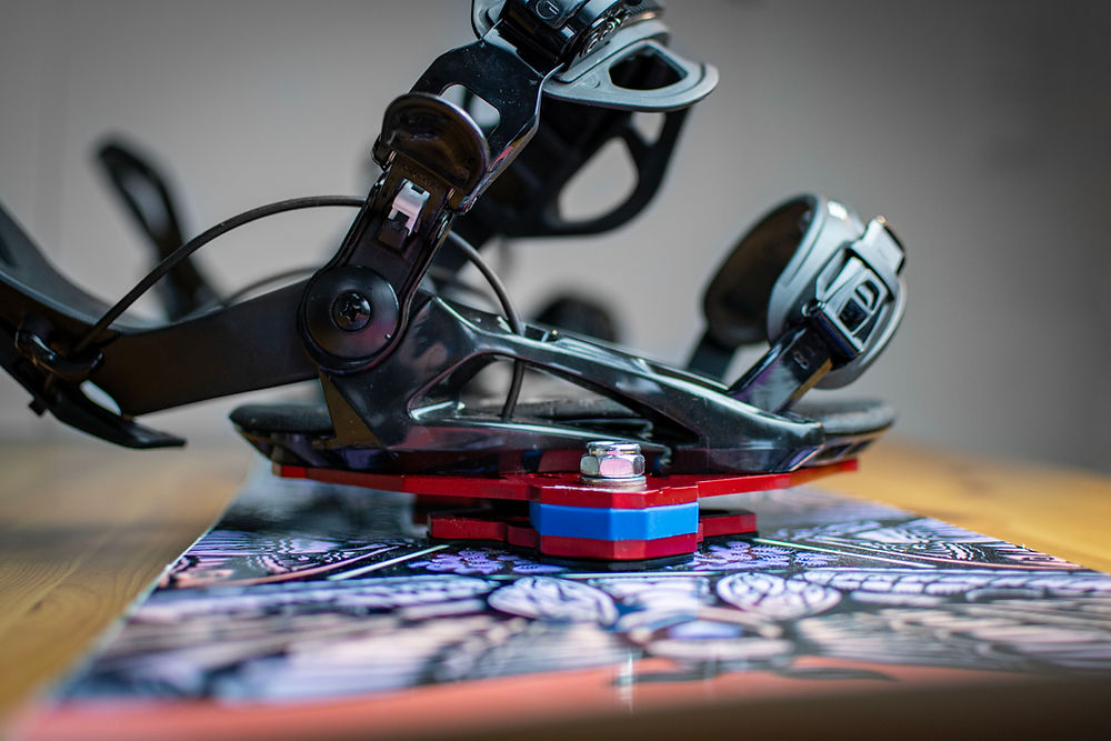 Snowboard binding with red and blue suspension system