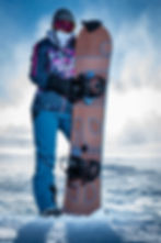 Snowboarder holding board equiped with ShredLORD in snowy landscape
