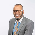 Dr Seleem wearing a grey suit and tie.