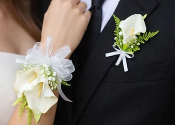 Young couple at their school ball wearing their artificial cala lily wrist corsage and matching buttonhole designed by Floret Designs.