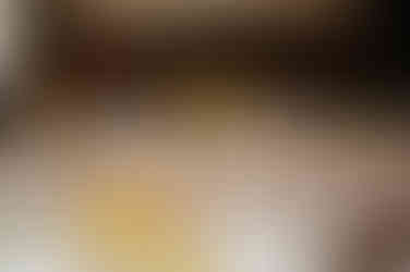 Close-up of airy yellow florals illuminated by warm candle glow, creating a soft and romantic tabletop detail.