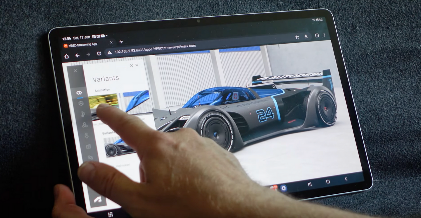 A hand navigating a tablet running a VRED visualization.