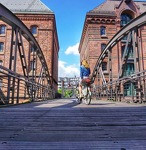 Fahrradtour Hamburg City Tour - Der Klassiker: Eine Radfahrerin fährt über die Kippelstegbrücke in der Speicherstadt