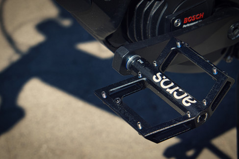 Nahaufnahme eines ACROS‑Plattformpedals mit Kurbelarm und Antriebsbereich am Nicolai EBOXX GT1, aufgenommen auf Pflaster.