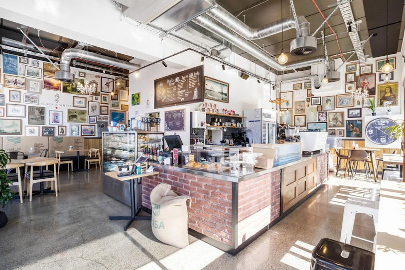 Black & White Cartel café in Auckland, featuring quirky art pitchers and a stylish black-and-white interior design that reflects the brand's unique personality and charm