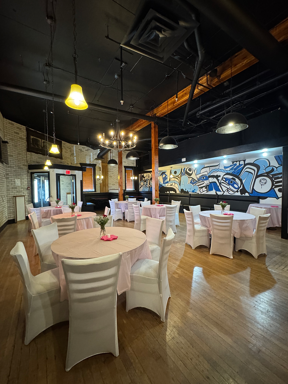 Dining room set with round tables and white chair covers in front of a blue mural