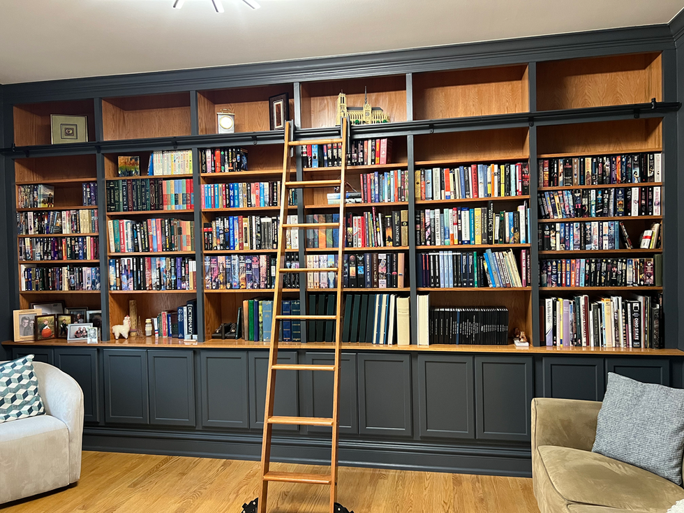 Large bookshelf with ladder and numerous books.