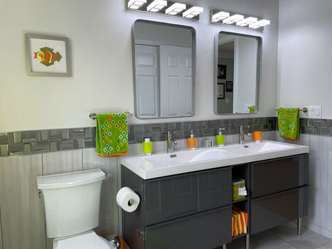 Modern bathroom with double sinks and colorful accents.