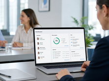 HR professional viewing VettingGateway background check dashboard showing candidate progress, audit trail and task lists in an office meeting