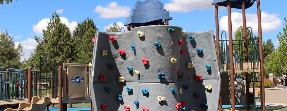 Larkspur park playground in Bend, Oregon kids rock climbing wall with colorful holds