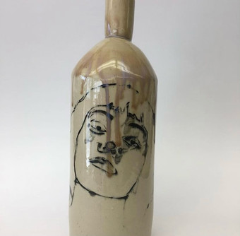 Mich's bottle with painted face and dripping brown glaze.