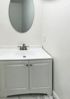 Modern ADU bathroom vanity with sink white cabinet and mirror.