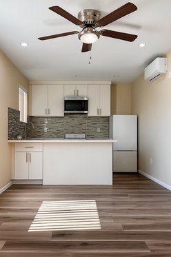 Modern ADU kitchen and living space with custom cabinets, quartz countertop, tile backsplash, ceiling fan, and wood-look flooring, completed by ILMA TRADE USA construction company.
