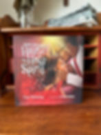 The book standing on a table. The cover of the book is a standing kissing his daughter's head.