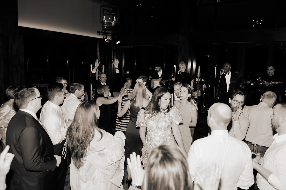 A bride dancing in the middle of her wedding party crowd with 8 piece band playing 
